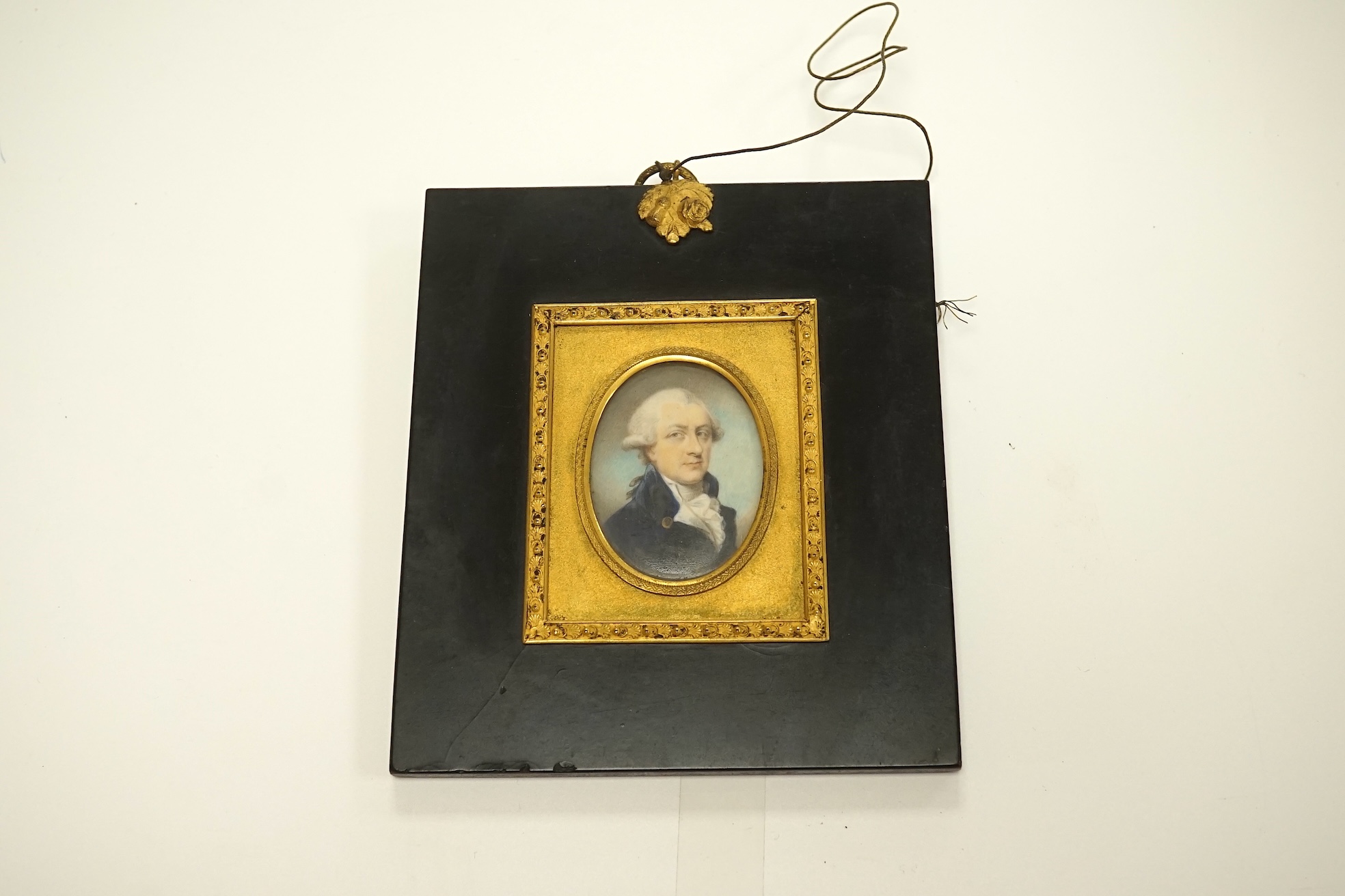 A George III portrait miniature on ivory of a gentleman wearing a frock coat, housed in an ebonised and gilt frame, 5.5 x 4cm. CITES Submission reference VF7NWZZA. Condition - fair to good.